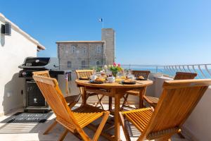einen Tisch und Stühle auf einem Balkon mit Grill in der Unterkunft MAISON PICASSO in Antibes