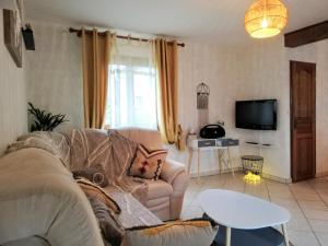 een woonkamer met een bank en een tv bij Scandi-house in Marly-la-Ville