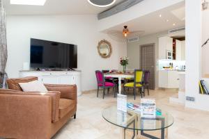 a living room with a couch and a table with chairs at MAISON PICASSO in Antibes