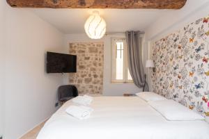 1 dormitorio con 1 cama y TV en la pared en MAISON PICASSO, en Antibes