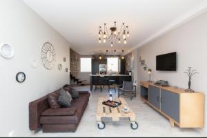 ein Wohnzimmer mit einem Sofa und einem Tisch in der Unterkunft Loft 3 pièces duplex 3 étoiles calme centre ville à 5 mn des plages et palais in Cannes