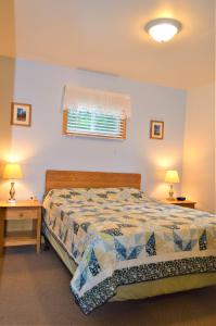 - une chambre avec un lit, deux tables et une fenêtre dans l'établissement Baileys Sunset Cottages, à Baileys Harbor