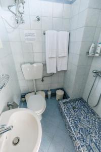 a white bathroom with a toilet and a sink at Mary's Studio Kavala in Kavála
