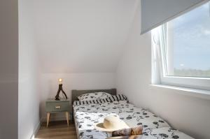 un pequeño dormitorio con una cama con sombrero en Domki Betina, en Jastrzębia Góra