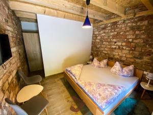 a room with a bed and a brick wall at Holiday park Hajducka cesma in Dubovsko