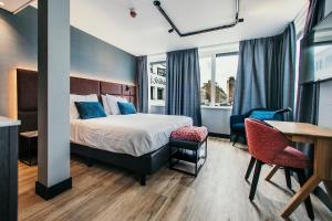 a hotel room with a bed and a table and chairs at Amsterdam Beach Hotel in Zandvoort