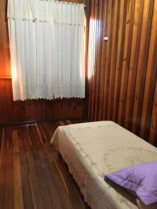 a bedroom with a bed and a window at Casa de Ferias Dona Inês in Treze Tílias