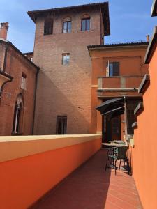 eine Terrasse mit einem Tisch und einem Sonnenschirm vor einem Gebäude in der Unterkunft Residenza del Duse in Bologna