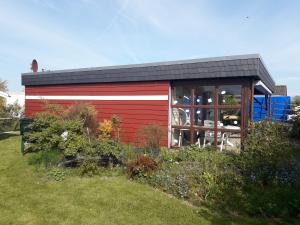 a red and white shed with a garden at Büsumer blaue Krabbe in Büsum