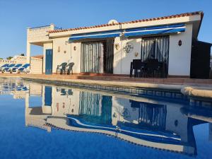 una casa con piscina frente a ella en Villa Azul, en Callao Salvaje