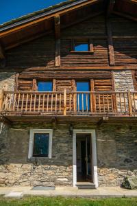 ein Haus mit einem Balkon an der Seite in der Unterkunft Nido delle aquile in Cogne
