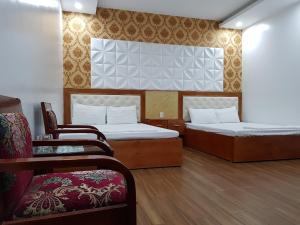 Xuan Thanh Hotel في Thanh Hóa: غرفة فندقية بسريرين وكرسي