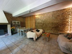 - un salon avec un lit et un mur en briques dans l'établissement Domaine De Marlas - Gîte de Charme, à Rieucros
