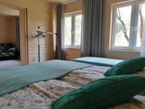 two beds in a room with two windows at Leśniczówka Kalina in Wetlina