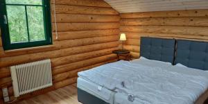 ein Schlafzimmer mit einem weißen Bett in einem Blockhaus in der Unterkunft Blockbohlenhaus in Wackersdorf