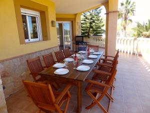 una mesa de madera y sillas en un patio en Villa Clairol, en Los Gallardos