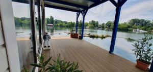 a boy standing on a dock with a view of a lake at Hausboat "Život na vode" in Bratislava