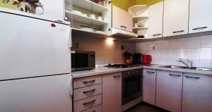 a kitchen with white cabinets and a white refrigerator at PARADISE Beach Apartments in Rovinj