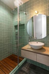 uma casa de banho com um lavatório e um chuveiro com um espelho. em Mare Cheia: Beach and Surf Apartment 2 na Consolação