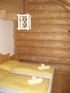 Cama en habitación con pared de madera en Bärenhütte Tröpolach-Nassfeld, en Jenig
