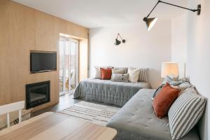 a living room with a couch and a fireplace at Mare Cheia: Beach and Surf Apartment 2 in Consolação