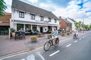 a couple of people riding bikes down a street at Hotel & Eetk'fee de VLiK in Ospel