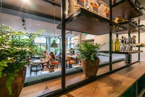 a bar with people sitting at tables in a restaurant at Hotel & Eetk'fee de VLiK in Ospel