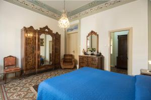 a bedroom with a blue bed and a mirror at B&B Via Roma in Marsala