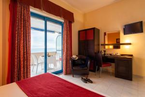 una camera d'albergo con letto, scrivania e finestra di Grand Hotel La Tonnara ad Amantea