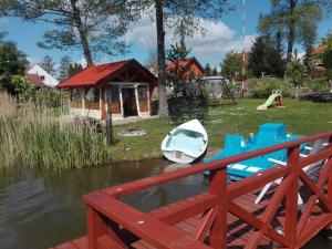 un barco en el agua junto a un parque infantil en Agro-Tur Domki w Szuwarach, en Kuty