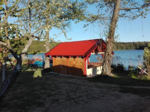 Cabaña roja con techo rojo junto a un lago en Agro-Tur Domki w Szuwarach en Kuty