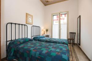 a bedroom with a bed with a blue and green comforter at B&B Via Roma in Marsala