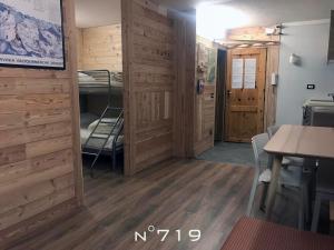 Habitación con paredes de madera y habitación con mesa y sillas. en House Cervinia Apartments, en Breuil-Cervinia