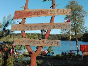 un cartel en frente de un lago con nombres de calle en Agro-Tur Domki w Szuwarach en Kuty