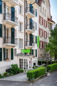 un edificio de apartamentos alto con un letrero verde. en Hotel Marthahaus en Berna