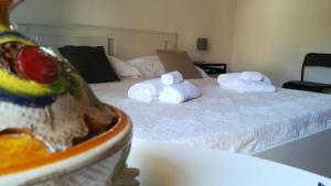 una camera con un letto con asciugamani e un piatto di cibo di The windows house a Siracusa