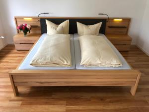 een bed met twee kussens in een kamer bij Haus Rebenblick in Dierbach