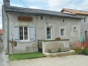 een wit huis met een bord erop bij Le Petit Brétigny in Beaumont