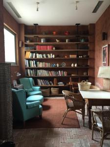 a living room with a library with a blue chair and a table at Hotel Boutique Moli El Canyisset in La Font D´En Carròs