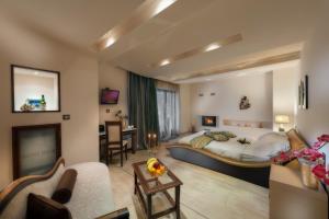 a bedroom with a large bed and a living room at Iakovakis Suites & Spa in Koropi
