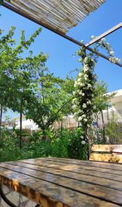 a wooden table with a bench and a flowering tree at La Primavera in Anacapri