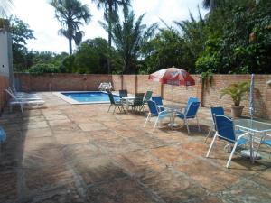 a patio with a table and chairs and an umbrella at Hotel Pousada Paraíso das Águas in Barreirinhas