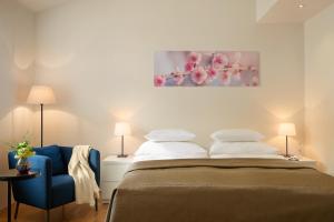 um quarto com uma cama e uma cadeira azul em Residence Vocelova em Praga