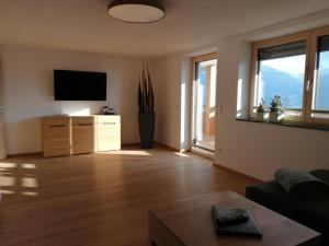 a living room with a flat screen tv and windows at Ferienwohnung La-Wurm in Hart im Zillertal