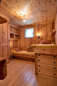 a log cabin with two beds and a window at Chesa Pradatsch Sur - Celerina in Celerina