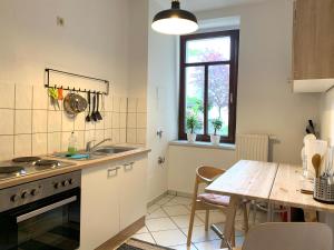 uma cozinha com uma mesa e uma mesa de jantar em Hinterhaus Apartment No4 em Leipzig