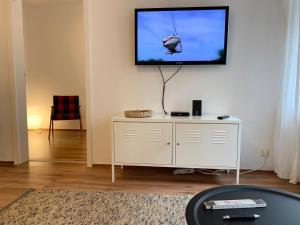 uma sala de estar com uma televisão de ecrã plano na parede em Hinterhaus Apartment No4 em Leipzig