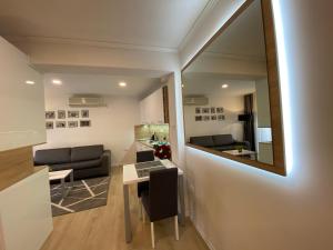 a living room with a table and a mirror at Apartments & Rooms Mostar Story in Mostar