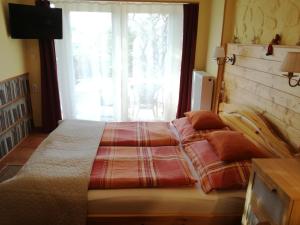 a bedroom with a large bed with a window at Virág Apartmanház in Sopron