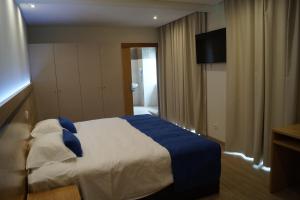 A bed or beds in a room at Angra Central Hotel